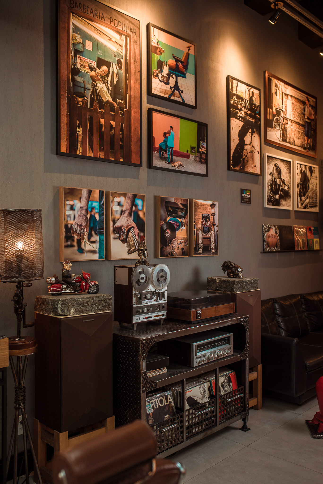 Salão da Mancave com poltronas de couro e parede de quadros